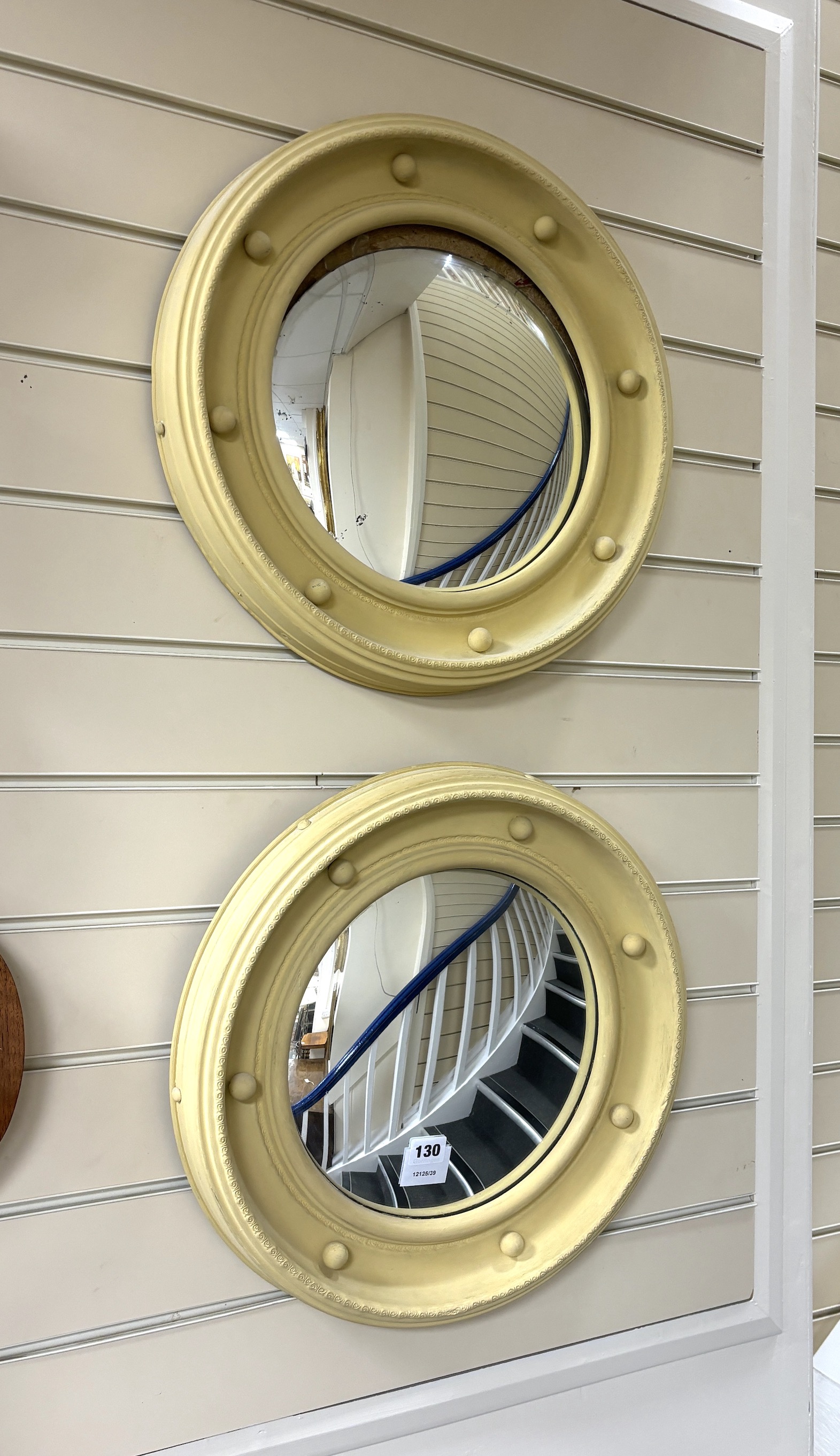 A pair of Regency style painted composition convex wall mirrors, diameter 44cm